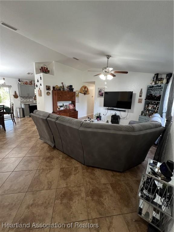 tiled living room with vaulted ceiling and ceiling fan