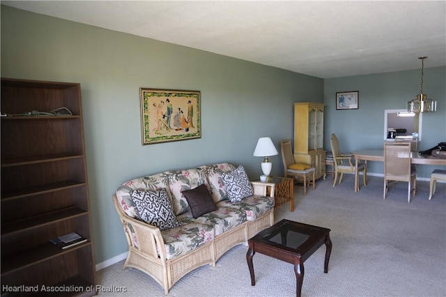 living room featuring carpet flooring and an inviting chandelier