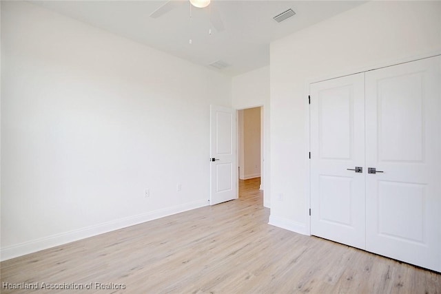 unfurnished bedroom featuring ceiling fan, light wood-type flooring, and a closet