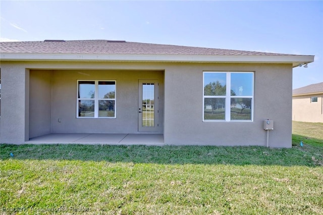 rear view of house with a yard and a patio