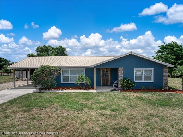 single story home featuring a front lawn, an attached carport, metal roof, driveway, and stucco siding