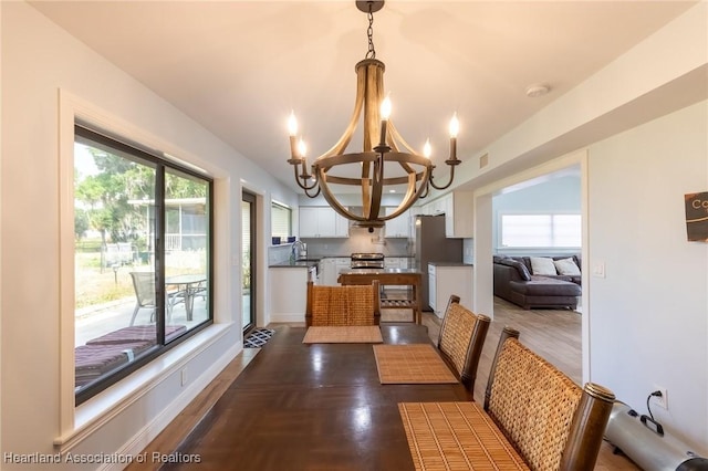 dining room featuring dark hardwood / wood-style floors, sink, and an inviting chandelier
