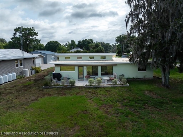 rear view of property featuring a patio area and a yard