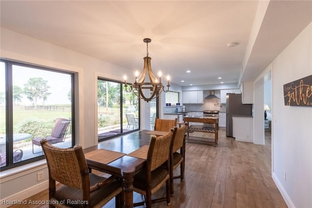 dining area with a notable chandelier and light hardwood / wood-style flooring