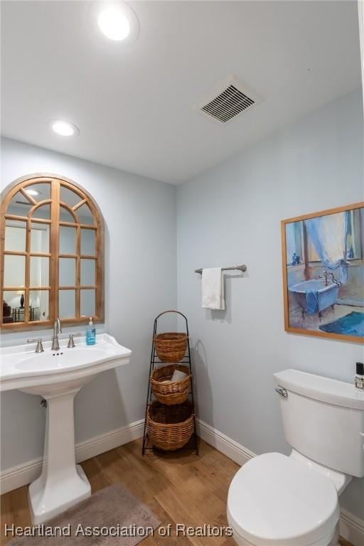 bathroom featuring hardwood / wood-style floors, toilet, and sink