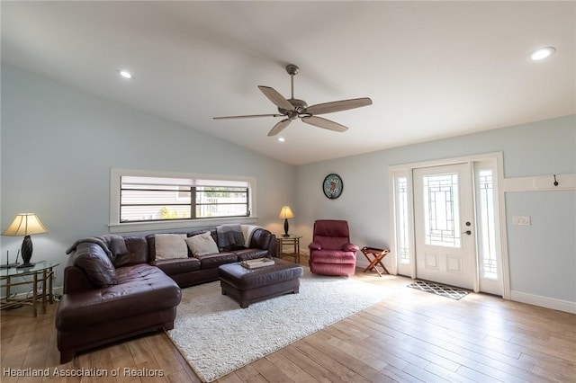 living room featuring light wood-type flooring, vaulted ceiling, plenty of natural light, and ceiling fan