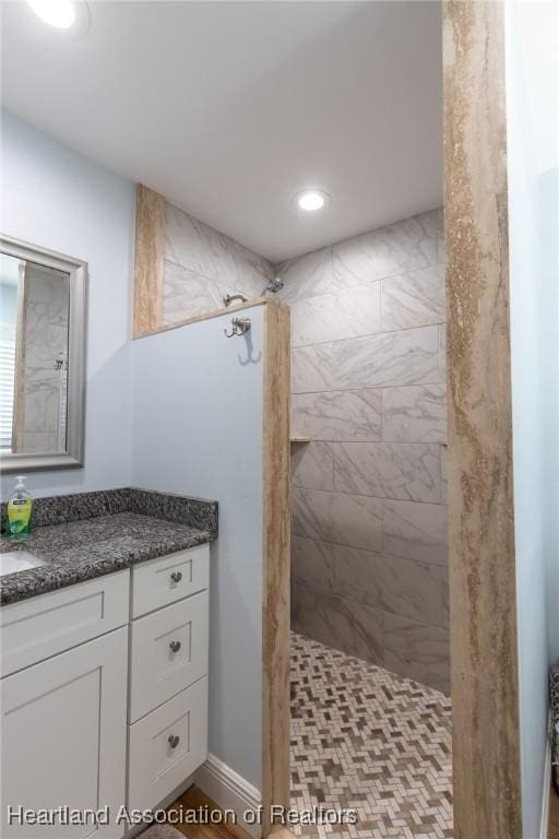 bathroom featuring vanity and tiled shower