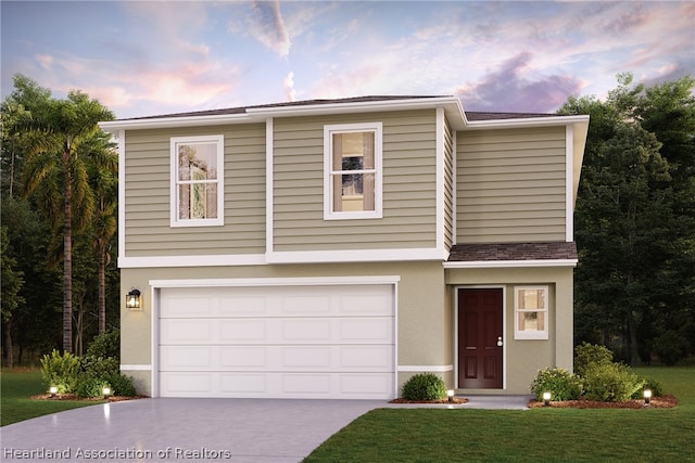 view of front of home with a yard and a garage