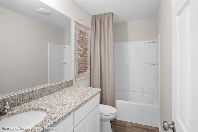 full bathroom featuring vanity, shower / bath combination, a textured ceiling, and toilet