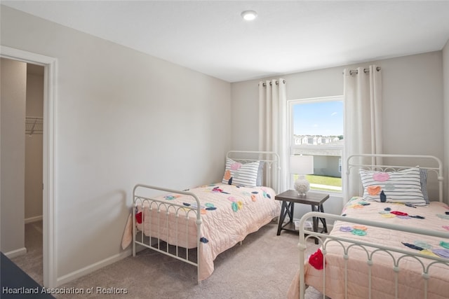 carpeted bedroom featuring a spacious closet and a closet