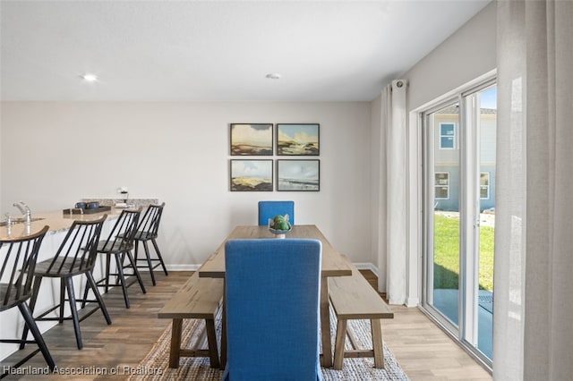 dining space with hardwood / wood-style floors and sink