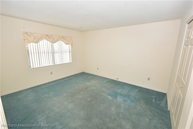 unfurnished room with dark carpet