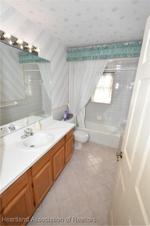 full bathroom with tile patterned flooring, tiled shower / bath combo, toilet, and vanity