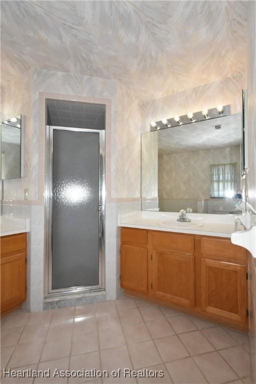 bathroom featuring tile patterned floors, vanity, and a shower with shower door