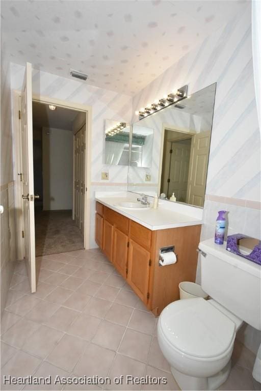 bathroom with tile patterned flooring, vanity, and toilet