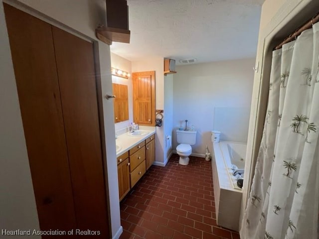 bathroom featuring vanity, toilet, and a washtub