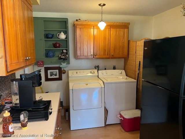 washroom featuring cabinets, independent washer and dryer, and light wood-type flooring