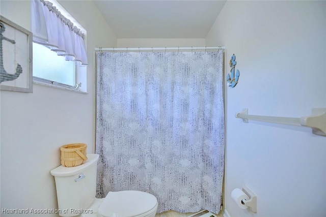 full bathroom featuring a shower with shower curtain and toilet