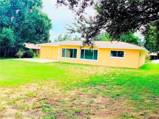 rear view of house with a yard and a patio area