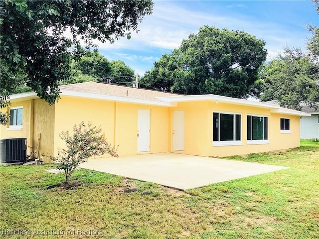 rear view of house featuring central AC, a patio, and a lawn