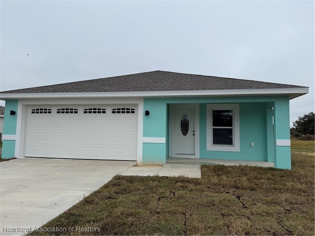 view of front of home featuring a front yard and a garage