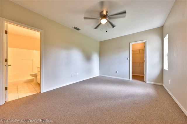 4021 Page Ave, Sebring, FL 33875 - unfurnished bedroom featuring carpet, a walk in closet, ensuite bath, ceiling fan, and tile patterned flooring
