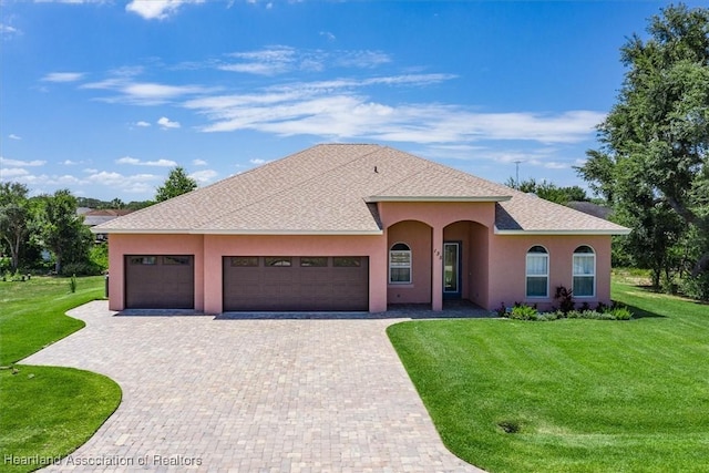 view of front of home with a garage and a front lawn