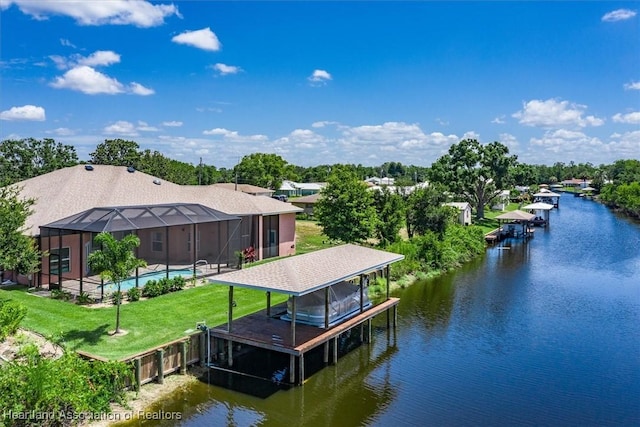 dock area with a yard, a water view, and glass enclosure