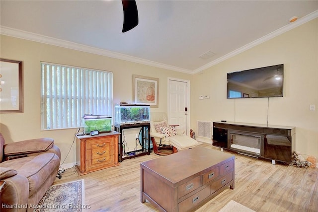 living room with crown molding, light hardwood / wood-style flooring, ceiling fan, and vaulted ceiling