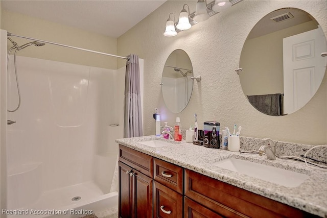 bathroom with walk in shower and vanity