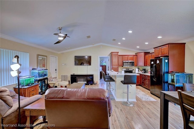 living room featuring crown molding, lofted ceiling, ceiling fan, and light hardwood / wood-style floors