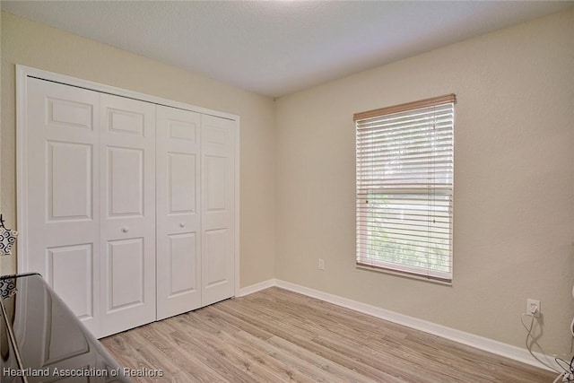 unfurnished bedroom featuring a closet and light wood-type flooring