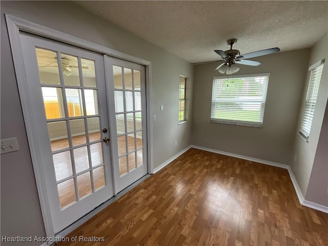 doorway with french doors, wood finished floors, baseboards, a textured ceiling, and a ceiling fan