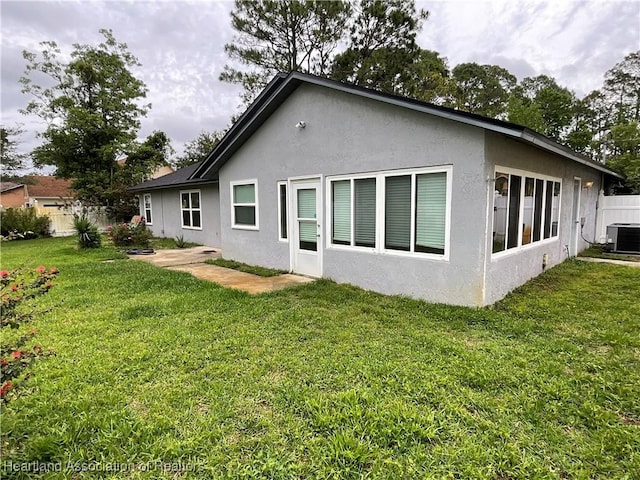rear view of house with central AC and stucco siding