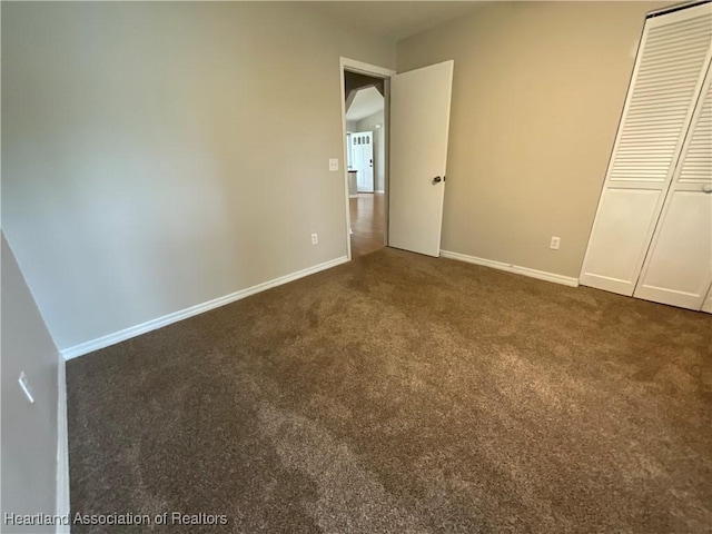 unfurnished bedroom with carpet floors, baseboards, and a closet