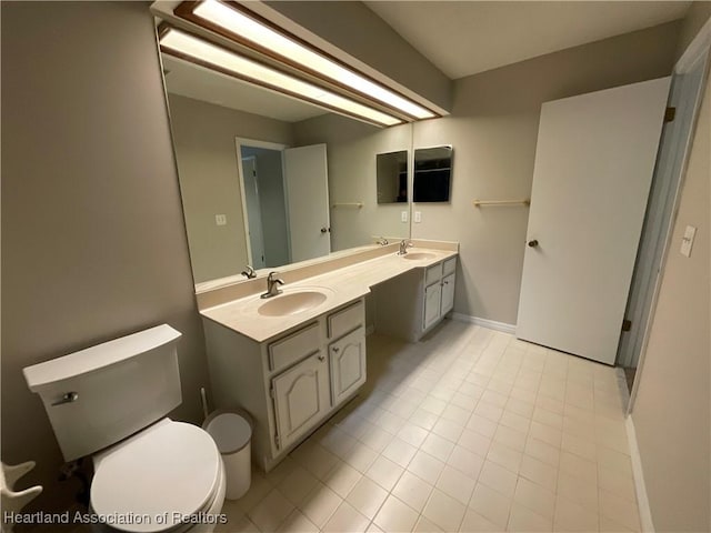 full bath featuring toilet, double vanity, tile patterned flooring, and baseboards