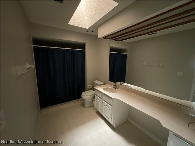 bathroom with vanity, a skylight, toilet, tile patterned flooring, and a shower with curtain