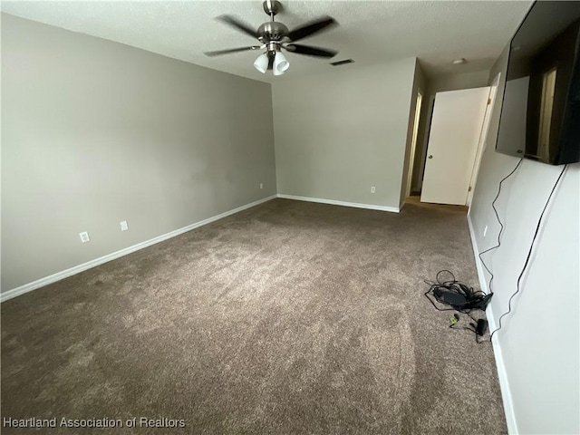 carpeted spare room with a ceiling fan, baseboards, and a textured ceiling