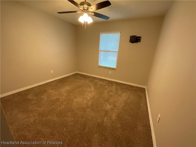 unfurnished room with dark carpet, baseboards, and a ceiling fan