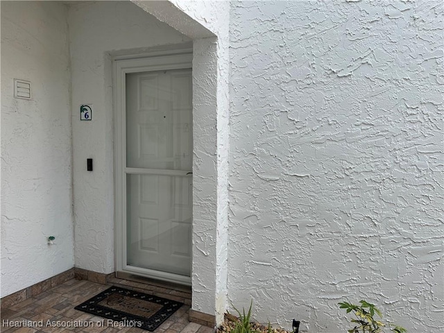 view of exterior entry with stucco siding