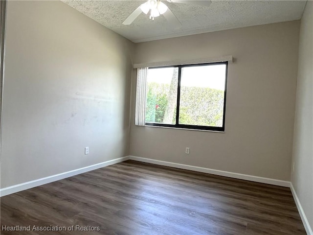 unfurnished room with dark wood-style floors, a textured ceiling, and baseboards