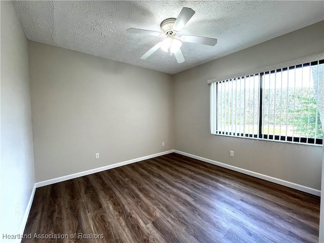 unfurnished room featuring dark wood-style floors, a textured ceiling, a ceiling fan, and baseboards