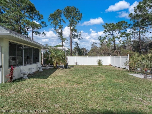 view of yard with a fenced backyard and a sunroom