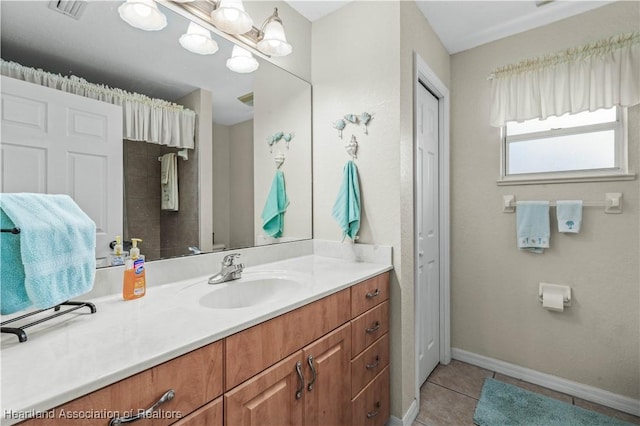 bathroom featuring visible vents, vanity, baseboards, and tile patterned floors