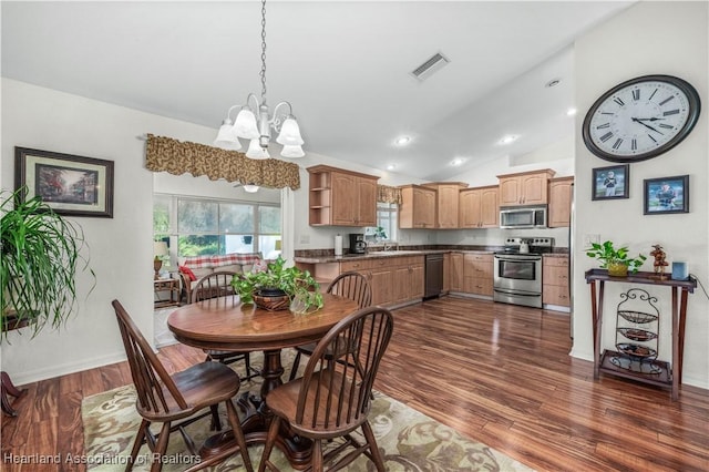 dining room with dark wood-style floors, a chandelier, visible vents, and vaulted ceiling