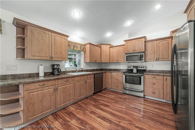 kitchen featuring vaulted ceiling, appliances with stainless steel finishes, open shelves, and a sink