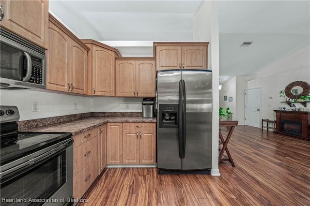 kitchen featuring stainless steel appliances, dark countertops, visible vents, and dark wood-style floors