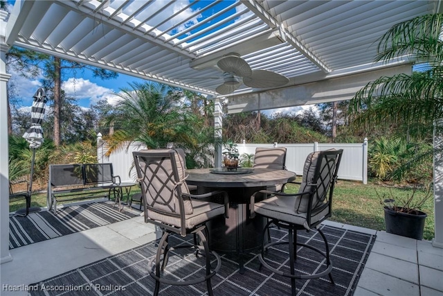 view of patio / terrace with outdoor dining area, ceiling fan, fence, and a pergola