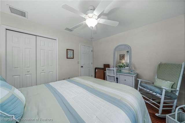 bedroom featuring a ceiling fan, a closet, visible vents, and wood finished floors