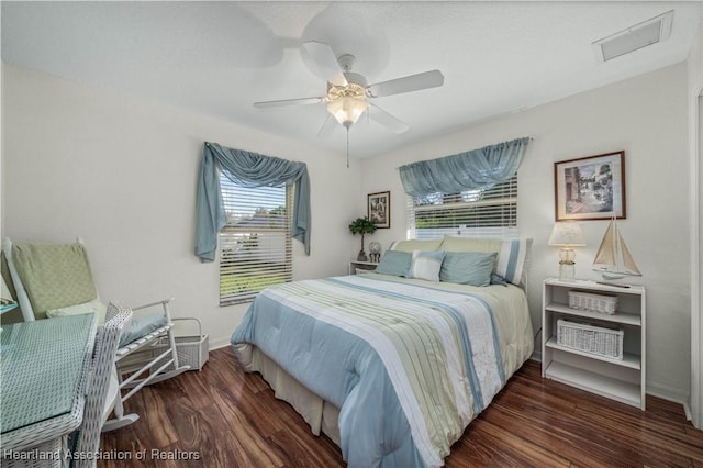 bedroom featuring wood finished floors, a ceiling fan, and baseboards